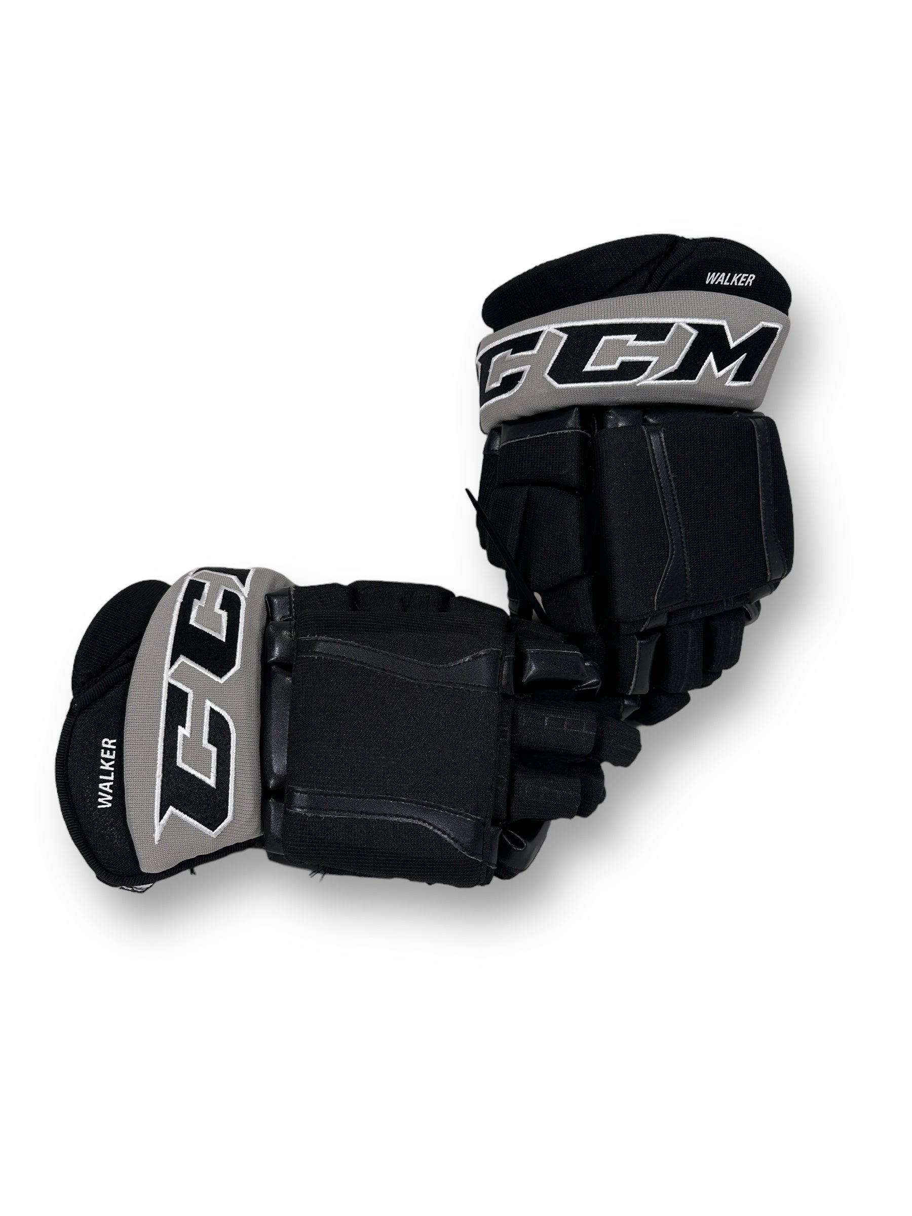 Backhand view of gloves with CCM embroidered on silver cuffs, with "WALKER" printed on the cuff roll in white.